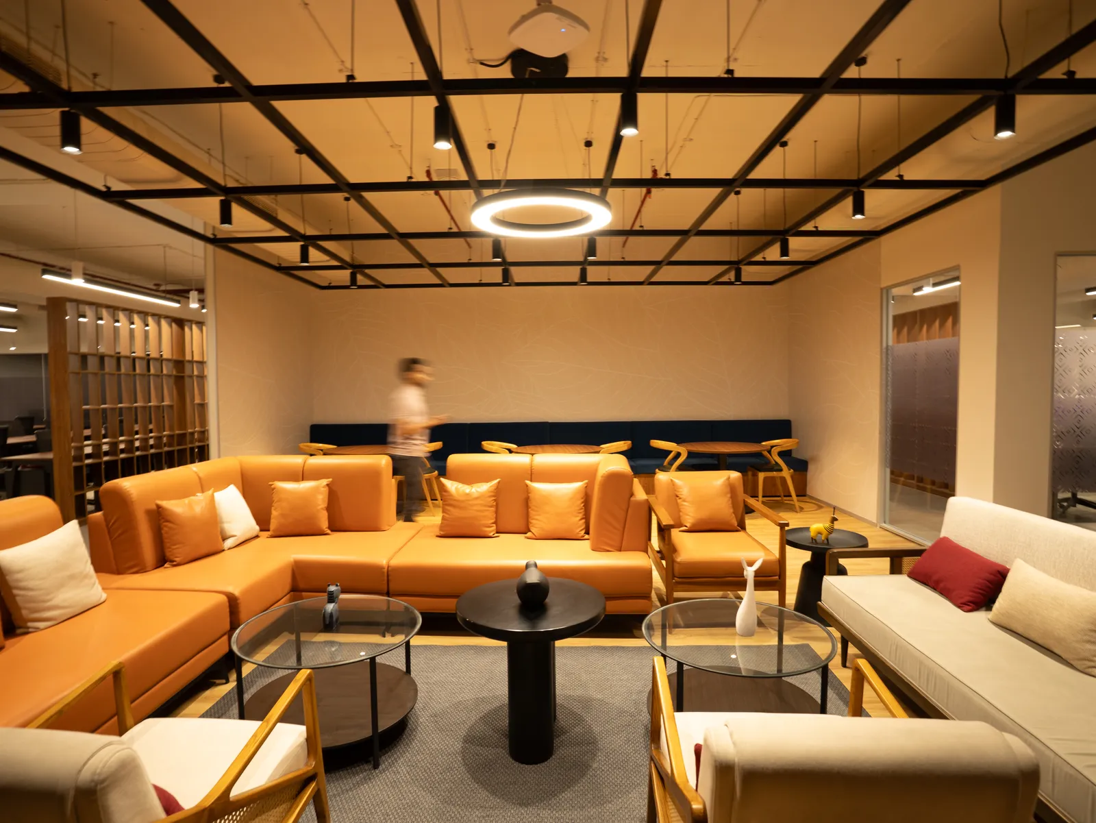 Lounge with tan sectional sofas and ring pendant light — Moschip